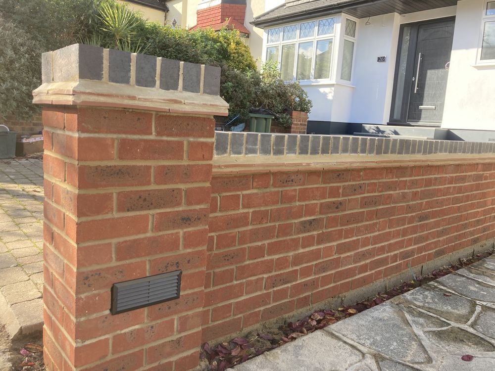Red brick garden wall with a dark brick topper